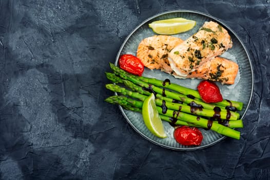 Tasty dish of trout, asparagus and tomato. Space for text.