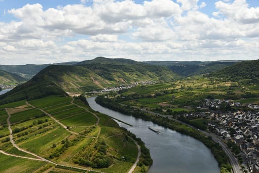 Bird's eye view of a village near the Moselle loop surrounded by greenery and vineyards in Germany