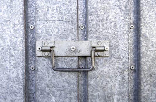 Detail of a metal handle to open and close a door on the street