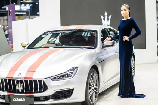Nonthaburi, Thailand - DEC 4, 2021 - Unidentified model poses with a car at The 38th Motor Expo Thailand 2021 at IMPACT Arena, Muang Thong Thani, Nonthaburi, Thailand.