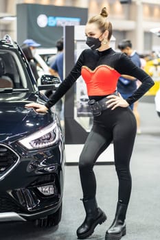 Nonthaburi, Thailand - DEC 4, 2021 - Unidentified model poses with a car at The 38th Motor Expo Thailand 2021 at IMPACT Arena, Muang Thong Thani, Nonthaburi, Thailand.