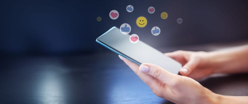 Woman's hands holding mobile phone on the black background. Concept of the social media and internet.