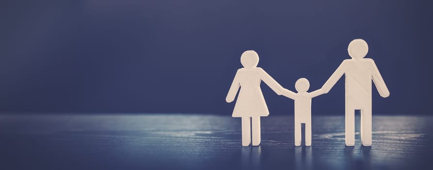 Figurine of the family on the black background. Abstract background.