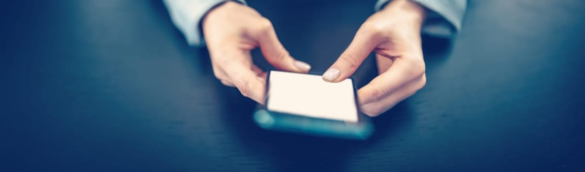 Woman holding in her hands a modern mobile phone. Concept of the e-commerce, business and surfering in network.