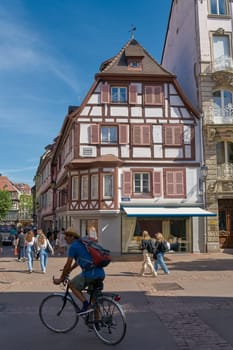 Tourists and a cyclist in the picturesque old town of Colmar in France