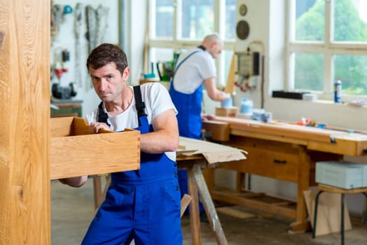 boss and worker together in a carpenter's workshop