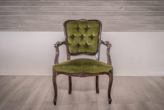 Green chair in victorian style on wooden floor