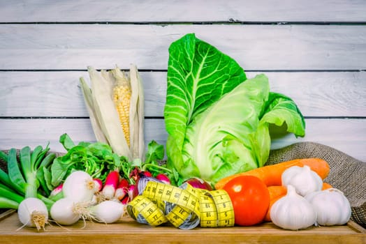 Mix of vegetables on a wooden table with measure tape