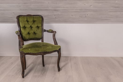 Green chair in victorian design on wooden floor