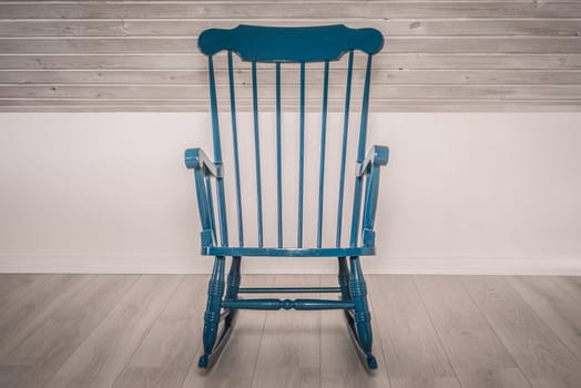 Blue rocking chair on a wooden floor