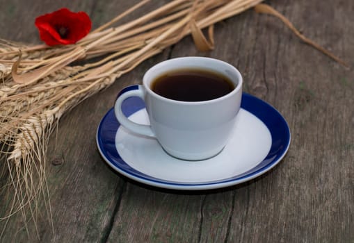 black coffee, wheat and flower of red poppy, still life on a subject drinks
