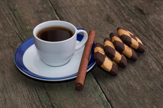 cup of coffee on a saucer with a blue border and cookies, a still life on a subject drinks