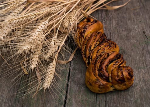 union of stalks of wheat and roll with poppy, a still life on a subject a natural food