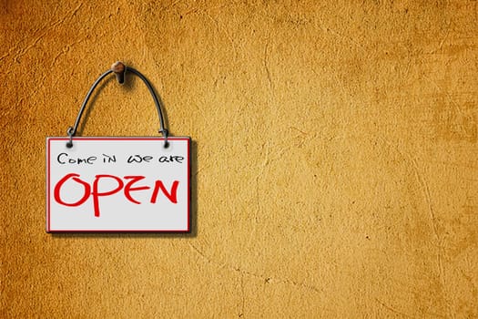 come in we are open hanging sign isolated on wall for adv or others purpose use