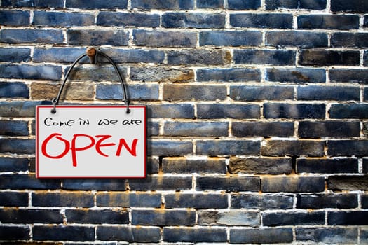 come in we are open hanging sign isolated on wall for adv or others purpose use