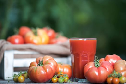 Fresh red tomato juice, on a wooden background