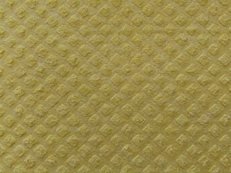 Close-up of fabric with embossed convex print. Bulging diamonds on yellow microfiber or dishwashing sponge. Background and free space for text.