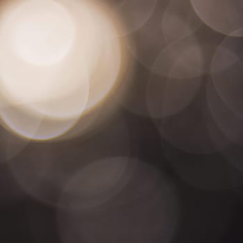 Abstract round bokeh - beige, gray, white. Bokeh is the blurring of an out-of-focus lens in a photograph. Festive blurred background