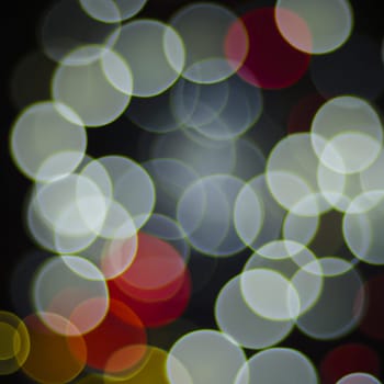 Multicolored abstract round bokeh - beige, white, gray, red. Bokeh is the blurring of an out-of-focus lens in a photograph. Festive blurred background