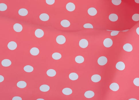 White polka dots on red pink background, textile fabric surface background