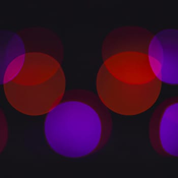 Multicolored abstract round bokeh - purple, lilac, red. Bokeh is the blurring of an out-of-focus lens in a photograph. Festive blurred background