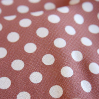 White polka dots on red background, textile fabric surface background