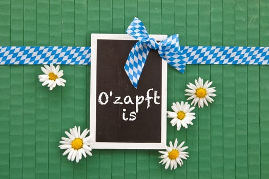 Small chalkboard on greens with marguerites and blue and white gift ribbon