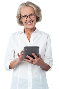 Happy senior woman operating digital tablet
