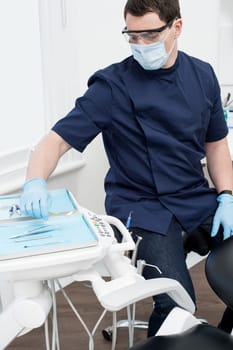 Dentist picking up tool for examine the patient