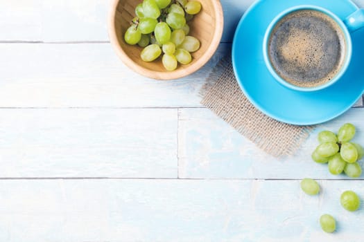 coffee cup with grapes and a wooden background