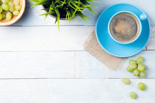 coffee cup with grapes and a wooden background