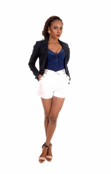 A slim young African American woman in white shorts and a grey jacket.and high heels, standing isolated for white background..