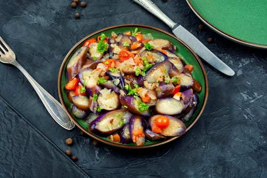 Grilled eggplant salad with parsley, garlic and tomato. Warm salad