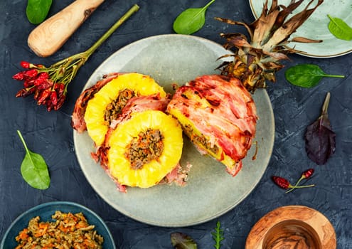 Tasty baked pineapple with spicy meat filling, wrapped bacon