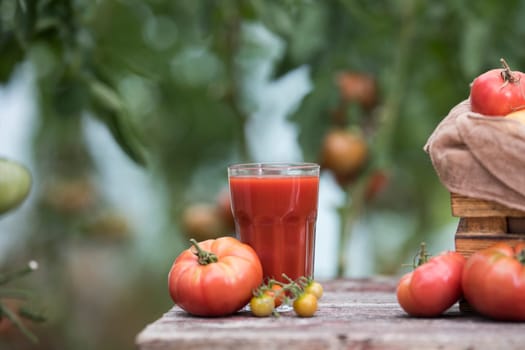 Fresh red tomato juice, on a wooden background