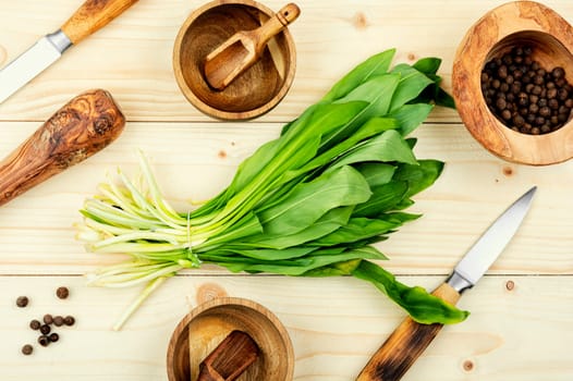Fresh wild garlic on rustic vintage table, wild garlic dishes. Healthy cooking concept, top view.