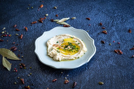 White plate of hummous handmade and olive oil ready to eat