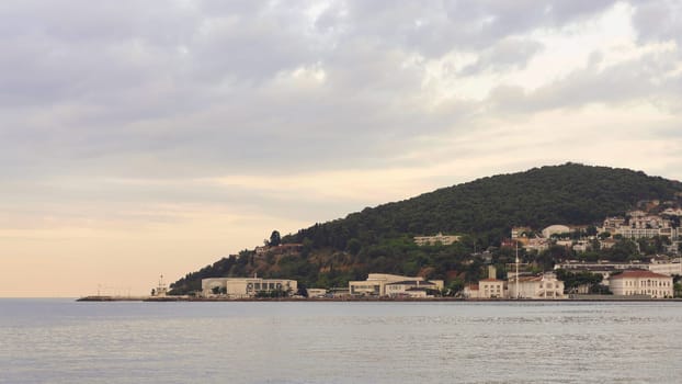 View of the mountains of Heybeliada island from Marmara Sea, with traditional summer houses and boats, Istanbul, Turkey