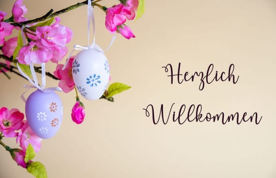 Beautiful Easter Egg Decoration With Spring Flowers. German Text Herzlich Willkommen Means Welcome. Seasonal Easter Holiday Greeting Card.