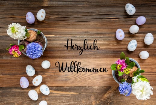 Easter Flat Lay With German Text Herzlich Willkommen Means Welcome. Flowers With Easter Egg Decoration And Ornament. Hyacinth Flower Arrangement With Wooden, Vintage Background.