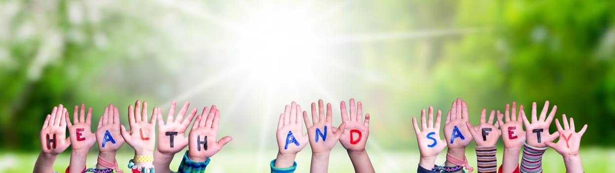 Children Hands Building Colorful English Word Health And Safety. Sunny Green Grass Meadow As Background.