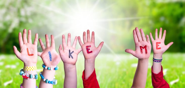 Children Hands Building Colorful English Word Like Me. Sunny Green Grass Meadow As Background.