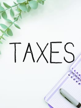 Hand writing sign Taxes, Word Written on contribution to state revenue levied by government on workers income