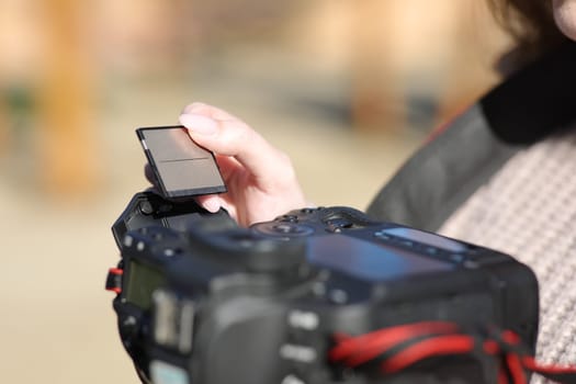 Close up of a photographer hand inserting compact card on camera