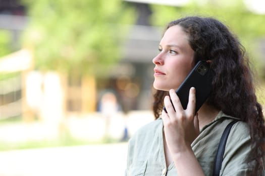 Woman talking on phone walking in the street