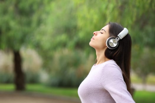 Profile of a woman breathing listening audio guide in a park
