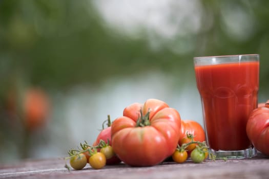 Fresh red tomato juice, on a wooden background