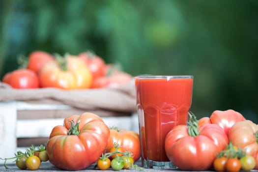 Fresh red tomato juice, on a wooden background