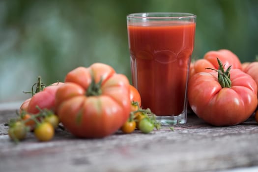 Fresh red tomato juice, on a wooden background