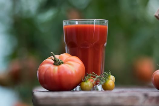 Fresh red tomato juice, on a wooden background